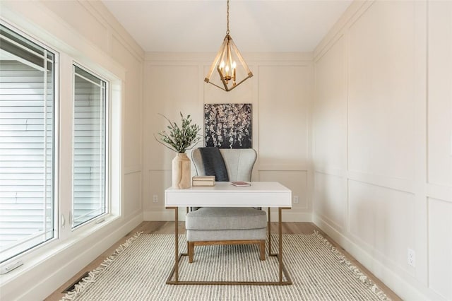 office space with a decorative wall, an inviting chandelier, and wood finished floors