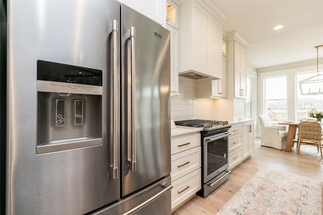 kitchen with tasteful backsplash, light countertops, light wood-style floors, white cabinets, and stainless steel appliances