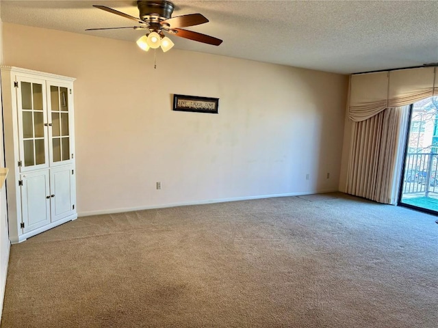 empty room featuring baseboards, a textured ceiling, ceiling fan, and carpet flooring