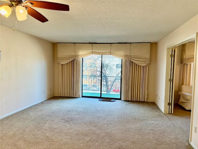 empty room featuring baseboards, a textured ceiling, ceiling fan, and carpet flooring