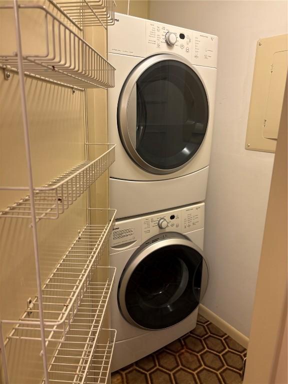 laundry room with laundry area, stacked washer / dryer, and baseboards