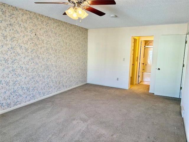 interior space with baseboards, a textured ceiling, wallpapered walls, and ceiling fan