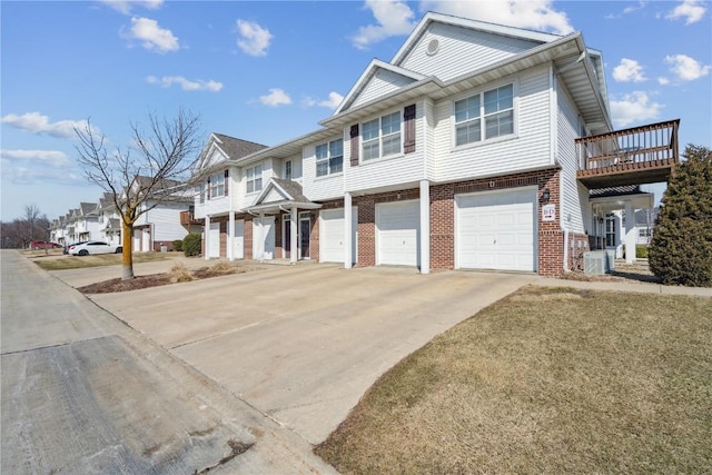 multi unit property featuring driveway, a residential view, an attached garage, brick siding, and central AC unit