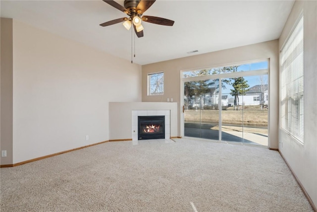 unfurnished living room with visible vents, ceiling fan, baseboards, carpet floors, and a fireplace