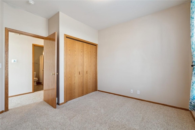 unfurnished bedroom featuring carpet flooring, baseboards, and a closet