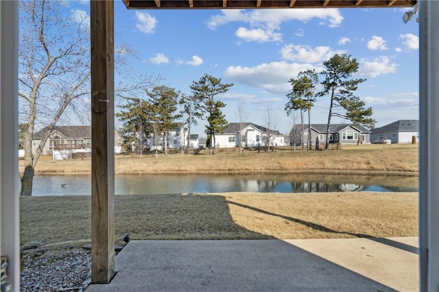 view of yard with a residential view and a water view