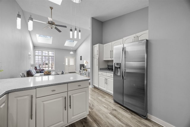 kitchen with a ceiling fan, light wood-style flooring, stainless steel refrigerator with ice dispenser, and white cabinetry