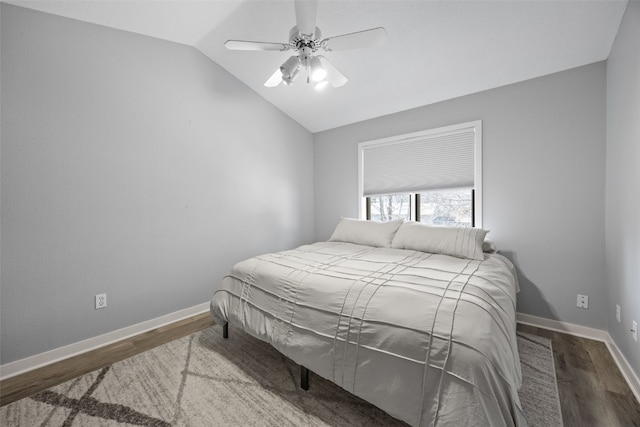 bedroom featuring baseboards, a ceiling fan, lofted ceiling, and wood finished floors