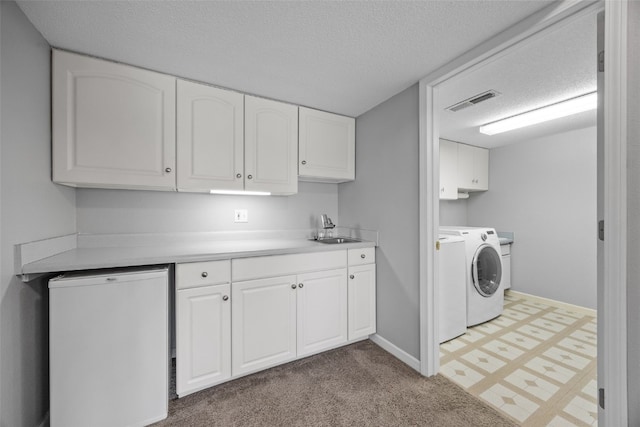 laundry area featuring baseboards, visible vents, cabinet space, a sink, and a textured ceiling