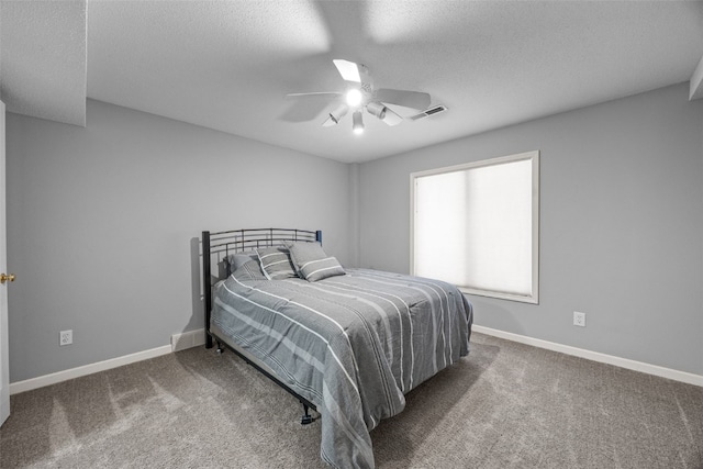 carpeted bedroom with visible vents, baseboards, a textured ceiling, and ceiling fan