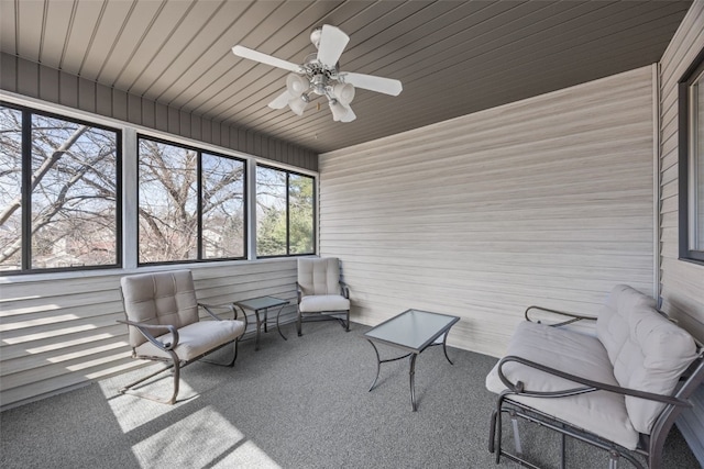 unfurnished sunroom featuring wood ceiling and a ceiling fan