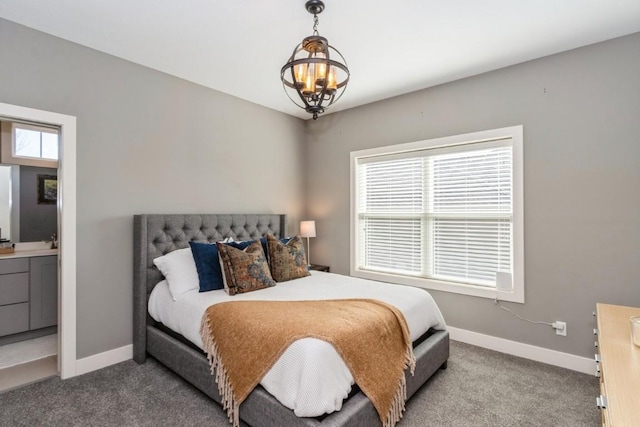 carpeted bedroom featuring baseboards and a chandelier