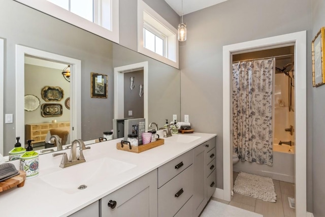 bathroom featuring a sink, toilet, double vanity, and shower / bath combination with curtain