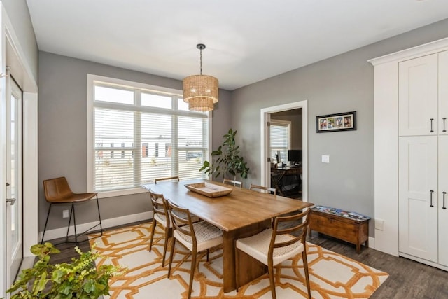 dining area with a notable chandelier, wood finished floors, and baseboards