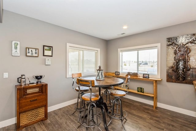 dining space featuring baseboards, plenty of natural light, and wood finished floors