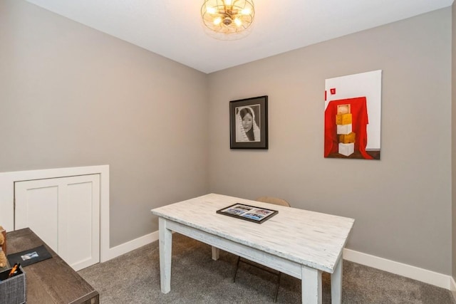 home office featuring dark colored carpet, baseboards, and an inviting chandelier