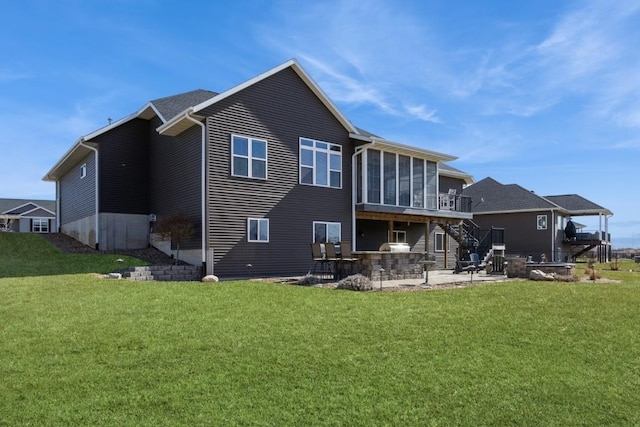 rear view of house featuring stairway, a yard, a sunroom, a deck, and a patio area