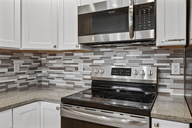 kitchen featuring light stone countertops, backsplash, appliances with stainless steel finishes, and white cabinetry