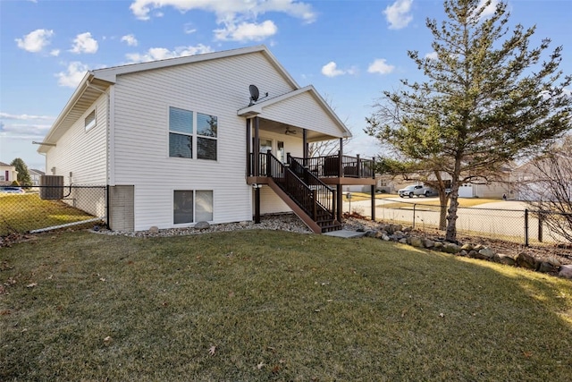 back of house featuring stairway, a lawn, and fence