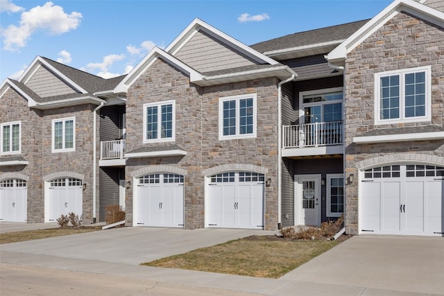 view of front of home with stone siding, an attached garage, and concrete driveway