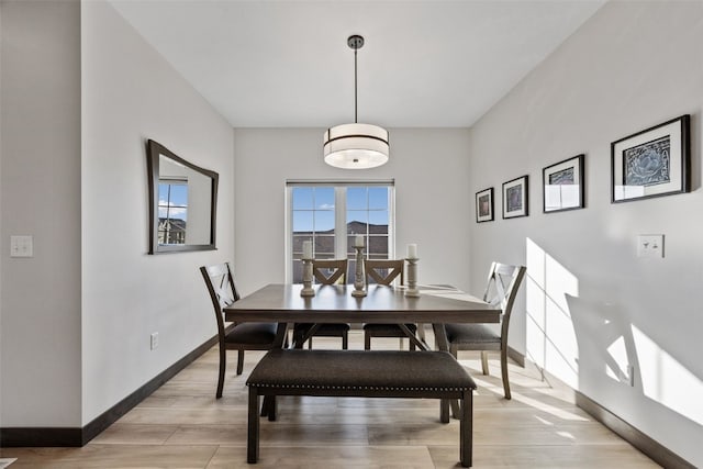 dining area featuring baseboards and light wood-style floors