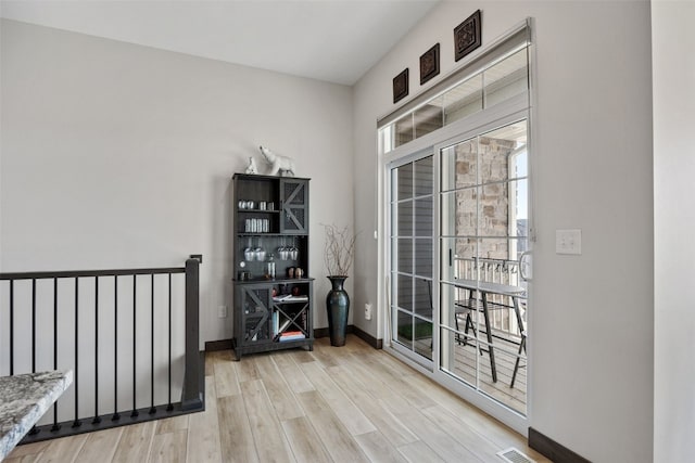 interior space with visible vents, baseboards, and wood finished floors