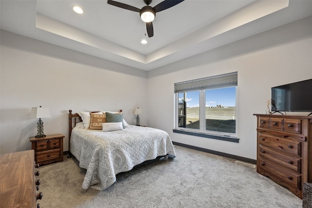 carpeted bedroom featuring recessed lighting, a ceiling fan, a tray ceiling, and baseboards