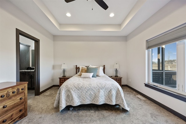 carpeted bedroom featuring a raised ceiling, visible vents, and baseboards