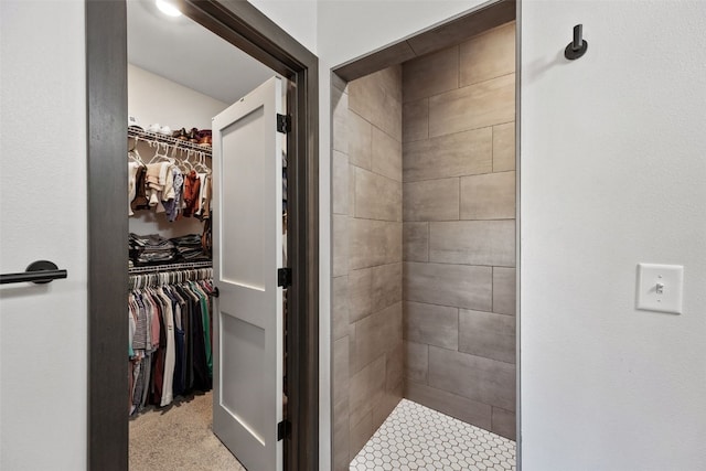 full bathroom with a spacious closet and a stall shower