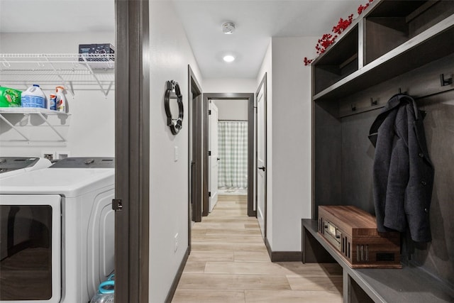 laundry area featuring wood tiled floor, baseboards, and washing machine and clothes dryer