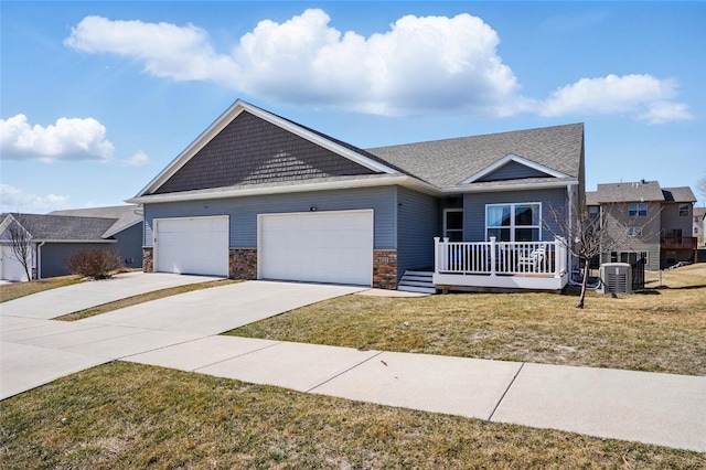 view of front of property featuring stone siding, an attached garage, driveway, and a front yard