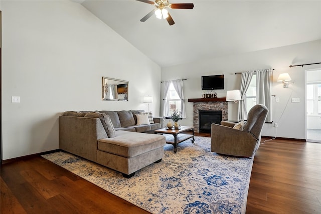 living area featuring high vaulted ceiling, a fireplace, wood finished floors, and a ceiling fan