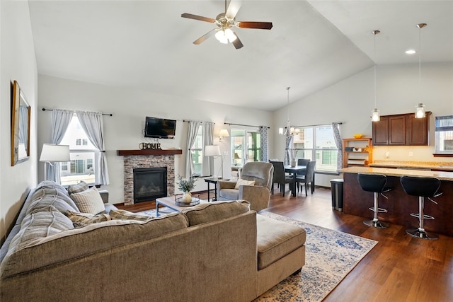 living room with a stone fireplace, high vaulted ceiling, dark wood-type flooring, and ceiling fan