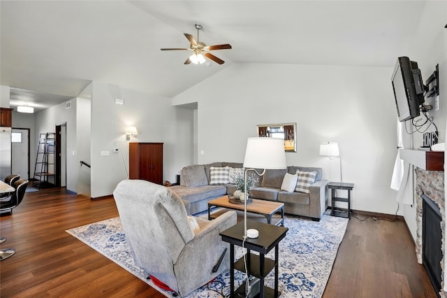 living area featuring a stone fireplace, wood finished floors, lofted ceiling, and ceiling fan