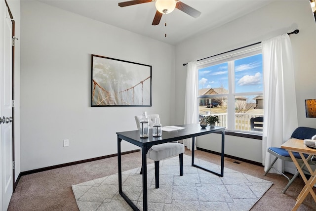 home office with baseboards, light carpet, and a ceiling fan