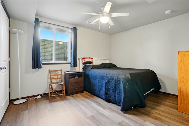 bedroom featuring a ceiling fan, wood finished floors, and baseboards