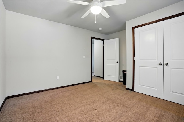 unfurnished bedroom with a ceiling fan, baseboards, a closet, and light carpet