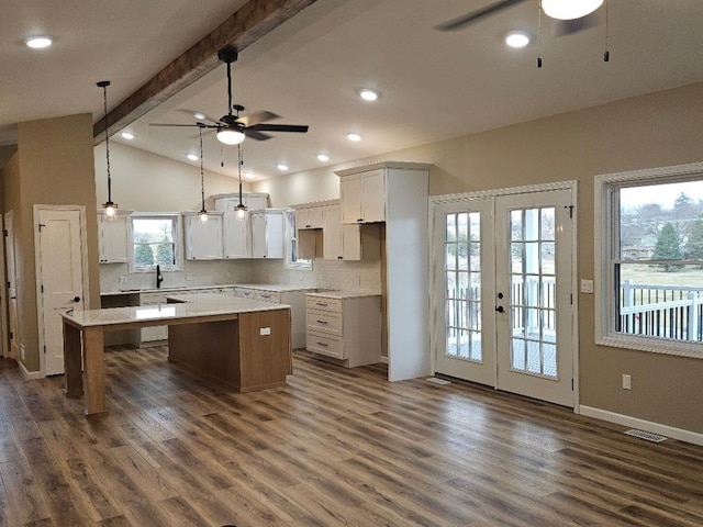 kitchen featuring dark wood finished floors, a kitchen island, lofted ceiling with beams, and a ceiling fan