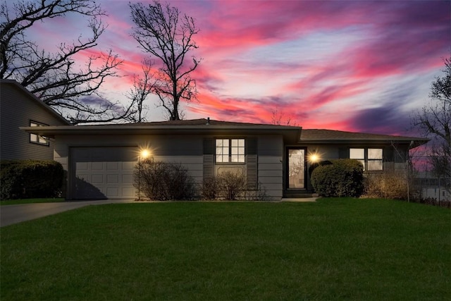 view of front of home with a lawn, an attached garage, and concrete driveway