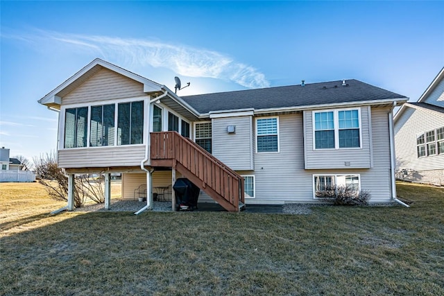 back of property with a lawn, a shingled roof, stairs, and a sunroom