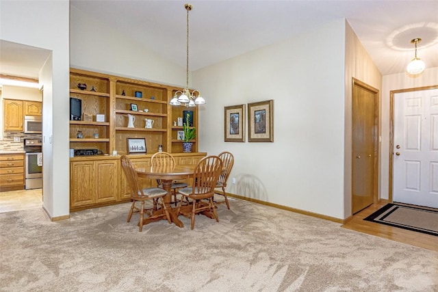 dining space with light carpet, baseboards, an inviting chandelier, and vaulted ceiling