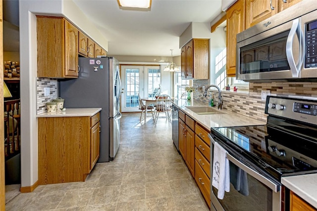 kitchen with a sink, stainless steel appliances, and brown cabinets