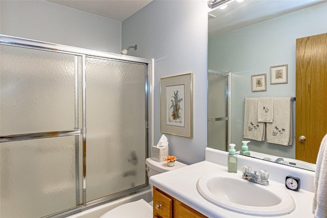 full bathroom featuring combined bath / shower with glass door, toilet, and vanity