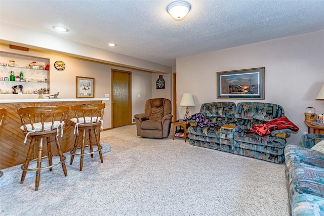 living area with a textured ceiling, a bar, recessed lighting, and carpet