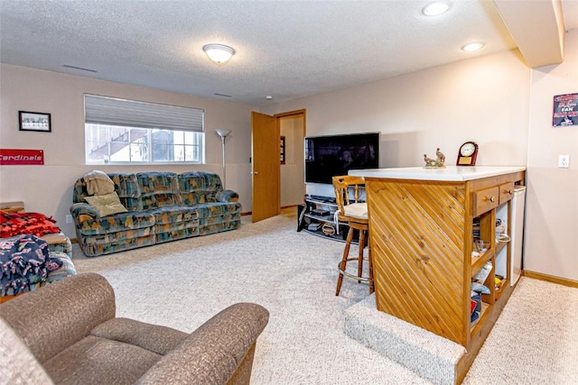 carpeted living area with baseboards and a textured ceiling