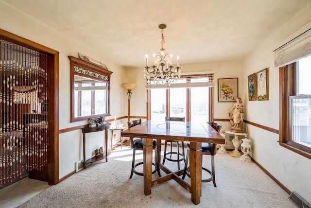 carpeted dining room with visible vents, baseboards, and an inviting chandelier