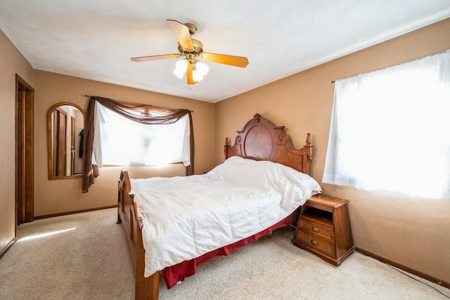 carpeted bedroom with baseboards and ceiling fan