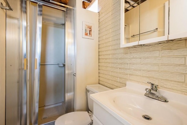 bathroom with a shower stall, toilet, and vanity