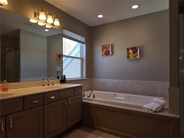 full bathroom with a sink, a garden tub, recessed lighting, and double vanity