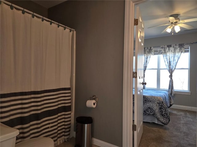 full bathroom featuring a shower with shower curtain, toilet, a ceiling fan, and baseboards